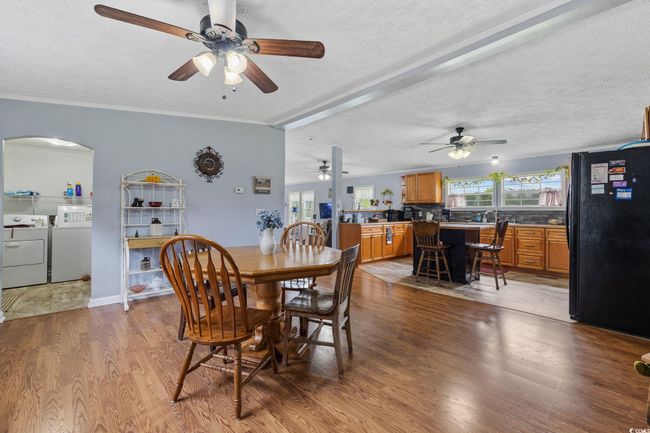 Kitchen with black appliances, ceiling fan, a wood stove, crown molding, and backsplash | Image 13