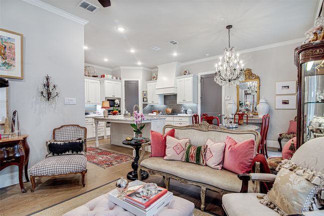 Living room featuring a chandelier, visible vents, crown molding, and light wood-style flooring | Image 15