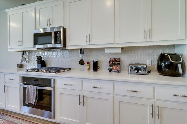 Kitchen featuring appliances with stainless steel finishes, light countertops, and tasteful backsplash | Image 14