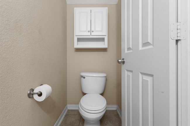 Half bathroom featuring toilet, baseboards, and tile patterned floors | Image 21