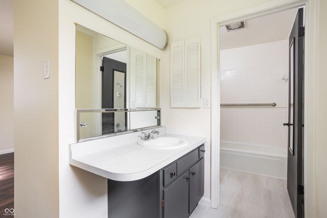 bathroom with wood finished floors, vanity, and washtub / shower combination | Image 28