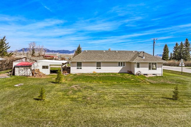 Back of property with a mountain view, an outdoor structure, and a lawn | Image 9
