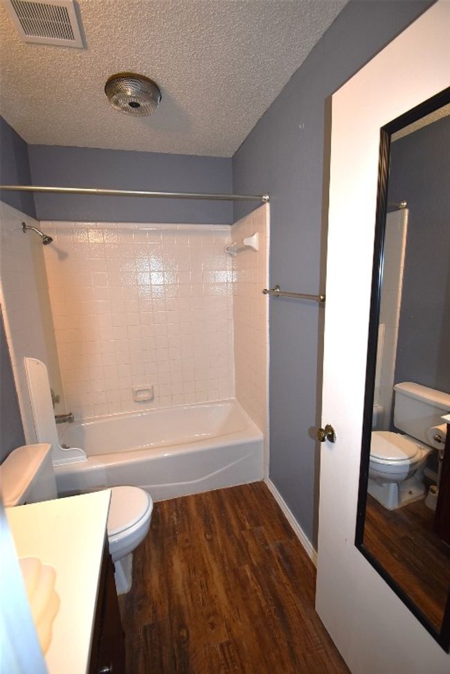 Full bath featuring shower / bath combination, wood finished floors, vanity, and a textured ceiling | Image 12