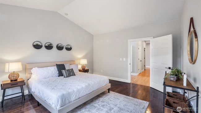 This downstairs primary bedroom showcases soaring vaulted ceilings and elegant hardwood flooring! | Image 10
