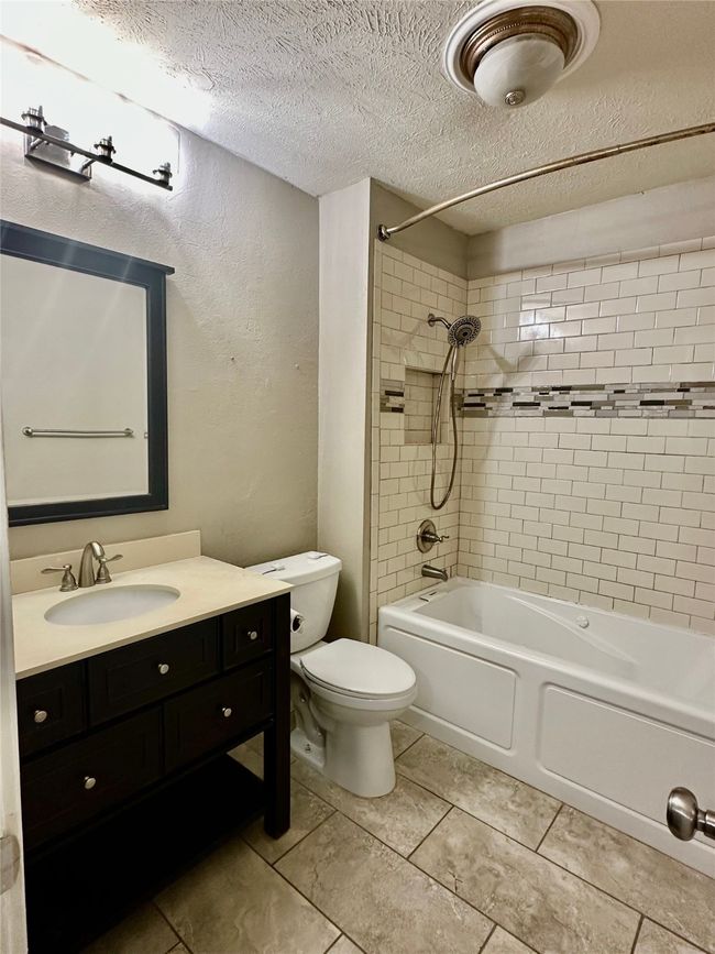 Full Bathroom featuring a textured ceiling, vanity, washtub / shower combination, and tile patterned flooring | Image 20