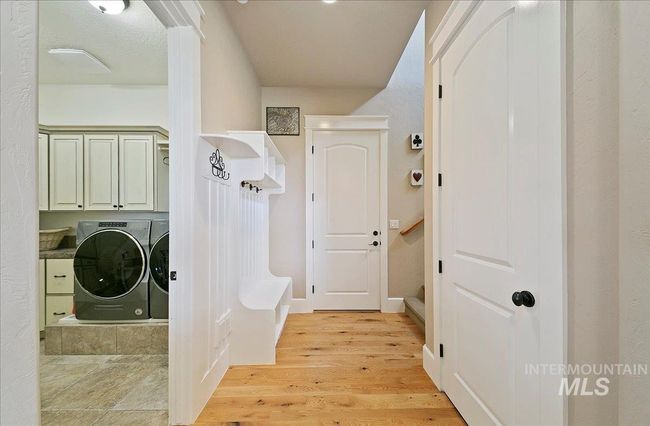 Laundry area featuring separate washer and dryer, cabinet space with sink, and tile floors | Image 27
