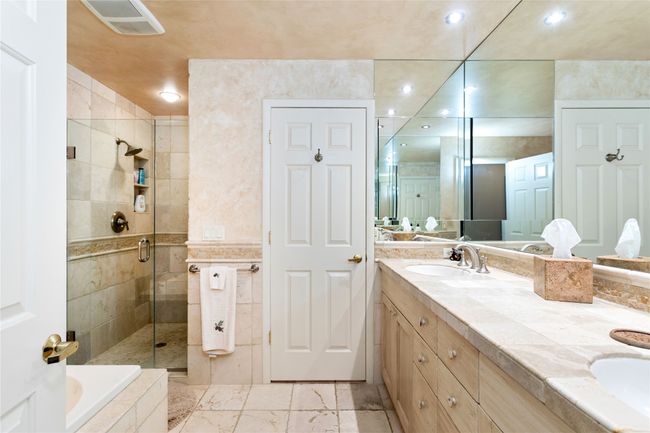 Bathroom featuring double vanity, a shower stall, recessed lighting, a bath | Image 23