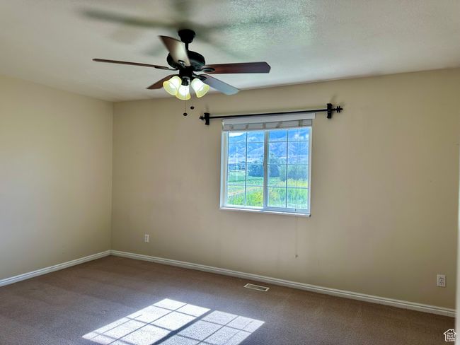 Nice-sized bedroom with fan and large window | Image 11