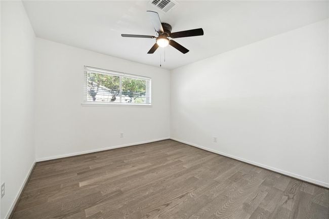 The first of three secondary bedrooms, filled with natural light. | Image 15