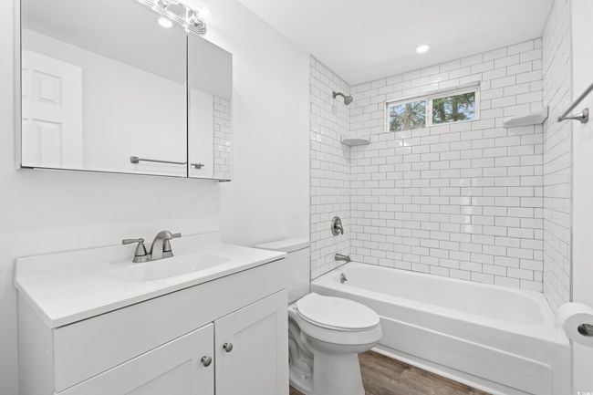 Bathroom featuring vanity, toilet, shower / bath combination, and wood finished floors | Image 14