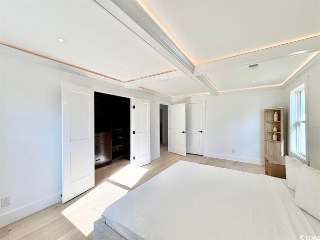 Bedroom with light wood-style floors, crown molding, beamed ceiling, and coffered ceiling | Image 20