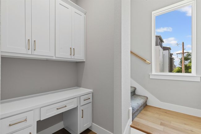Stairs with built in study area, wood finished floors, and baseboards | Image 11