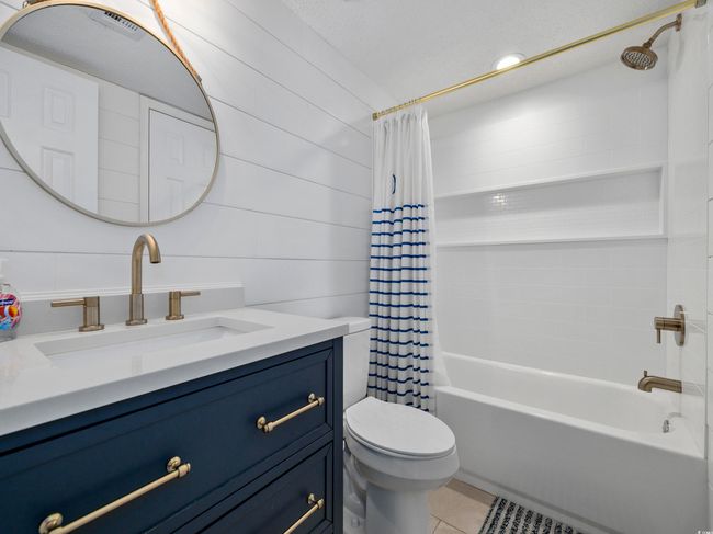Full bath with vanity, shower / bath combination with curtain, toilet, and tile patterned flooring | Image 20
