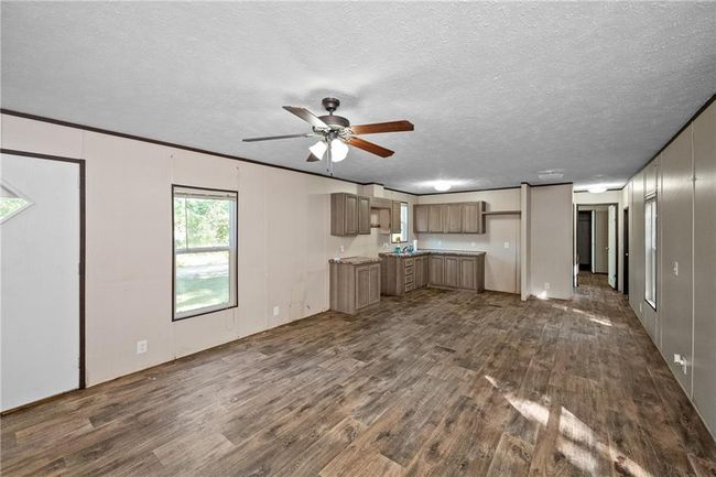 Unfurnished living room with dark wood-type flooring, ceiling fan, and a textured ceiling | Image 18