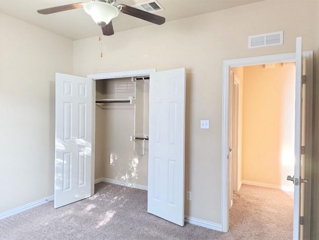 Unfurnished bedroom featuring carpet floors, a closet, baseboards, and a ceiling fan | Image 27