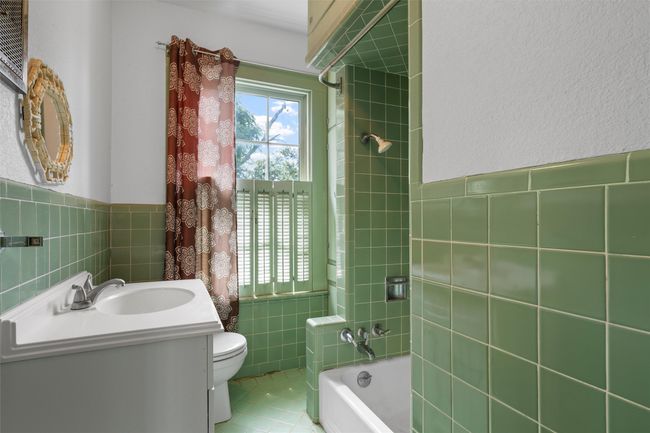 Bathroom with tile walls, vanity, shower / bathtub combination, wainscoting, and tile patterned floors | Image 29