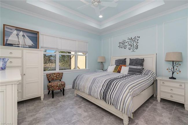 Bedroom featuring ceiling fan, ornamental molding, and a tray ceiling | Image 9