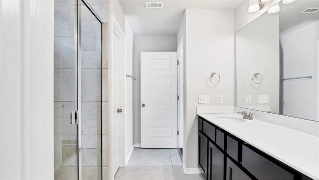 Bathroom with visible vents, tile patterned flooring, a stall shower, and vanity | Image 19
