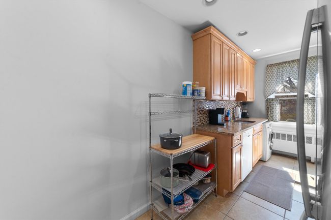 Kitchen featuring recessed lighting, radiator heating unit, dishwasher, light tile patterned floors, and a sink | Image 15