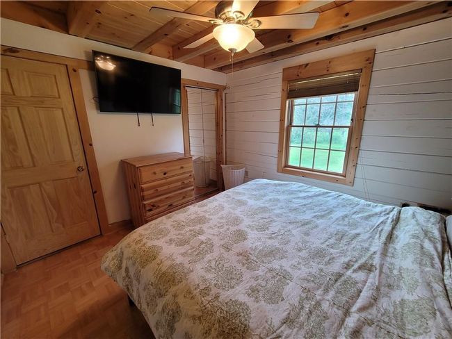 Bedroom featuring beam ceiling, parquet flooring, ceiling fan, and wood ceiling | Image 13