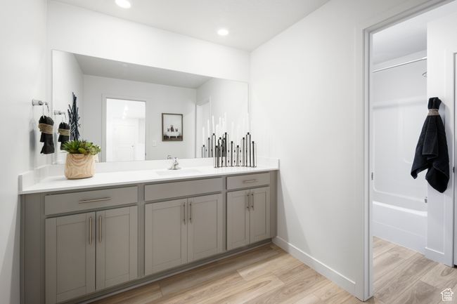 Bathroom featuring vanity, wood finished floors, baseboards, recessed lighting, and shower / washtub combination | Image 16