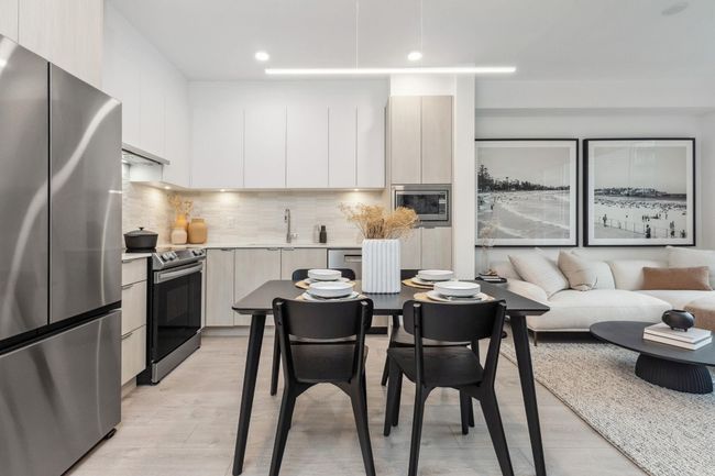 Kitchen featuring light countertops, light wood-style flooring, appliances with stainless steel finishes, and modern cabinets | Image 7
