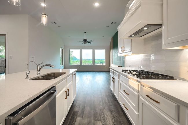 Kitchen with stainless steel appliances, premium range hood, a sink, a ceiling fan, and tasteful backsplash | Image 8