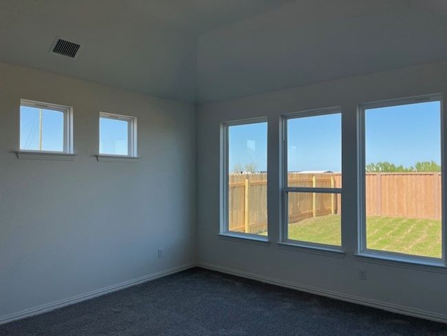 Spare room featuring dark colored carpet, visible vents, and baseboards | Image 4