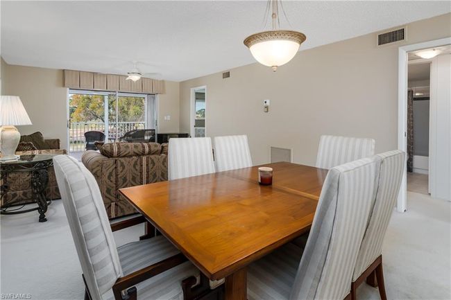 Dining area with a ceiling fan, visible vents, and light colored carpet | Image 7