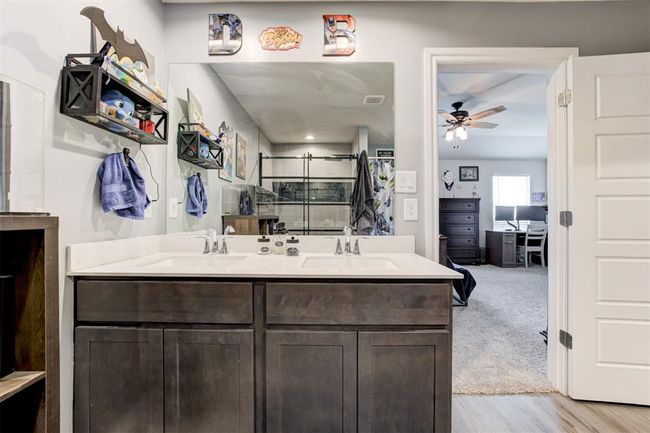 Bathroom with ceiling fan, double vanity, a shower with shower curtain, and wood finished floors | Image 27