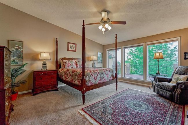 Three expansive windows in the primary bedroom offer natural light and serene views, with shades that can be raised or lowered for light or privacy. | Image 19
