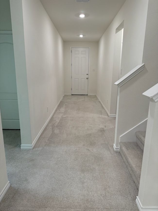 Hall with carpet, baseboards, and stairway | Image 4