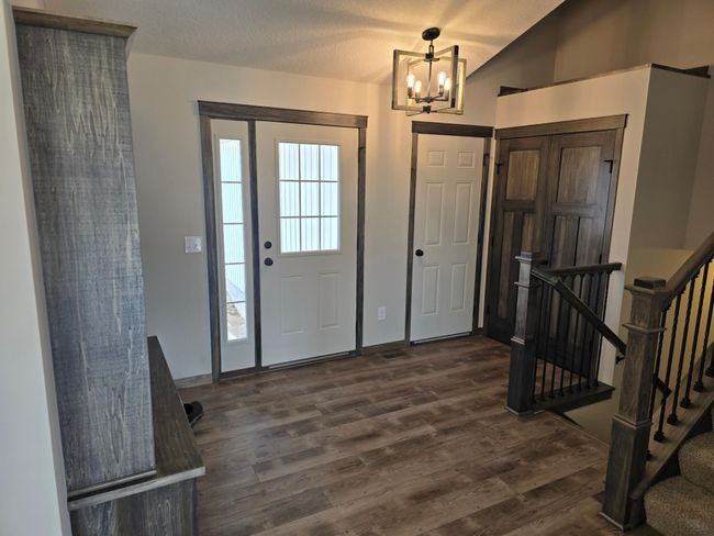 3 Paneled double swing doors on the entryway closet that is open above and has a wood cap. | Image 11