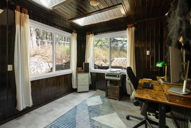 Office space with a skylight, wooden walls, and wooden ceiling | Image 23