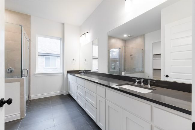 Full bathroom with double vanity, a shower stall, tile patterned flooring, and a spacious closet | Image 30