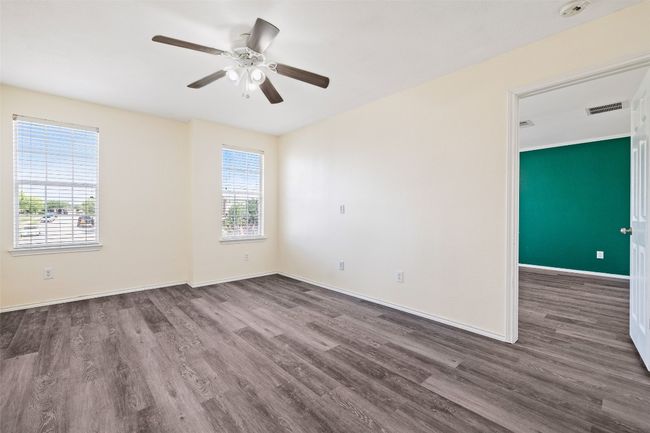 Empty room with wood finished floors, ceiling fan, baseboards, and a smoke detector | Image 32