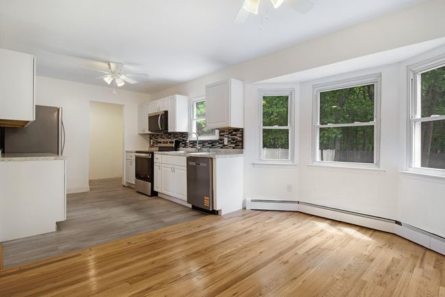 Kitchen with appliances with stainless steel finishes, ceiling fan, light wood-style flooring, and light countertops | Image 10