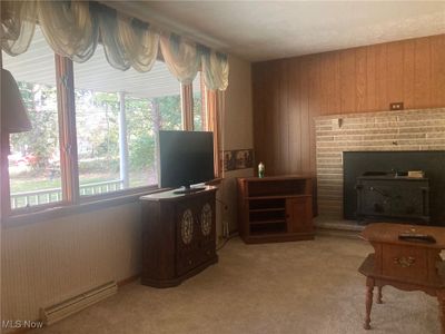 Carpeted living room featuring a woodburning fireplace | Image 3