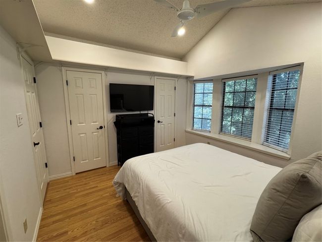 Bedroom featuring light wood-type flooring, high vaulted ceiling, and ceiling fan | Image 13