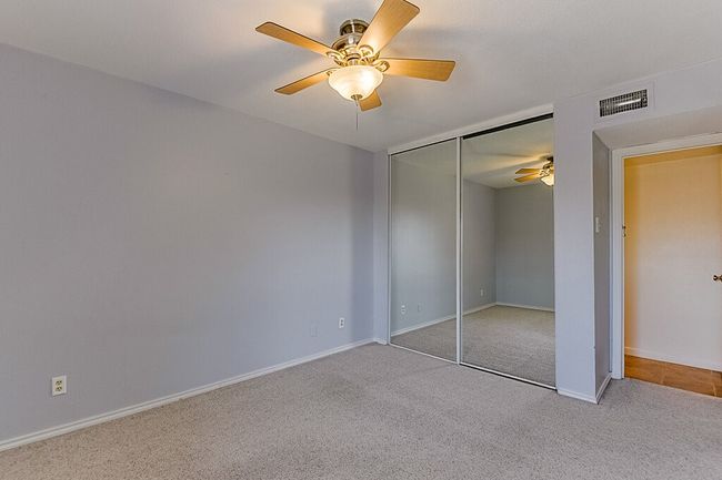 Unfurnished bedroom with a closet, baseboards, carpet flooring, visible vents, and ceiling fan | Image 19