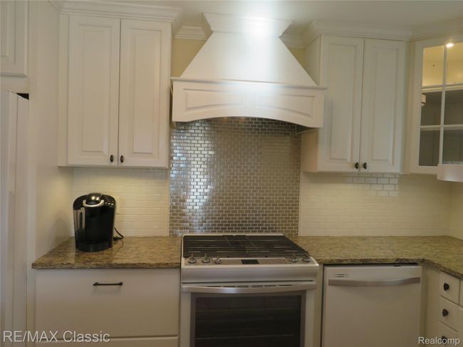 Subway tiled backsplash and accent wall behind the gas slide in range | Image 8