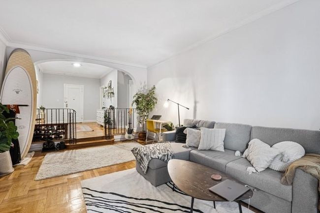 Living area with arched walkways, baseboards, and ornamental molding | Image 6