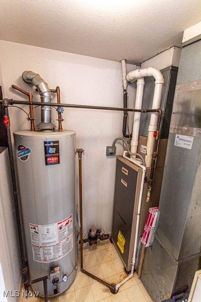 Utility room featuring water heater and heating unit | Image 15