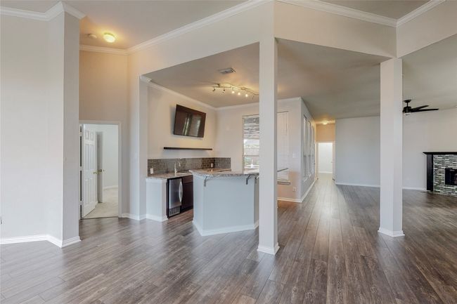 Kitchen featuring ceiling fan, open floor plan, dark wood finished floors, a fireplace, and refrigerator | Image 10