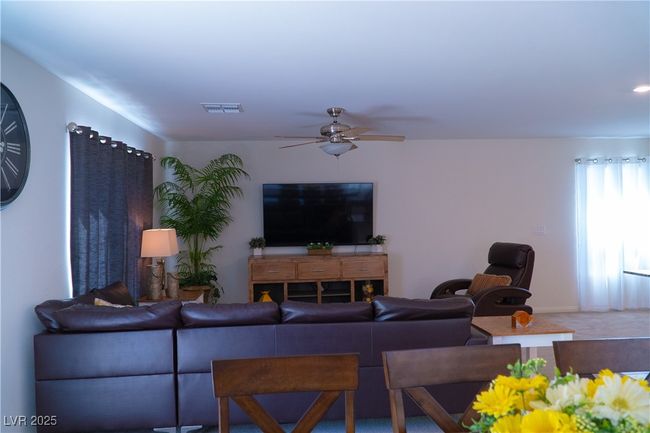 Living room featuring carpet flooring, visible vents, and ceiling fan | Image 31