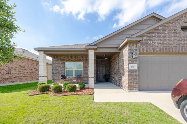 View of front of home featuring brick siding, a front lawn, an attached garage, and concrete driveway | Image 9