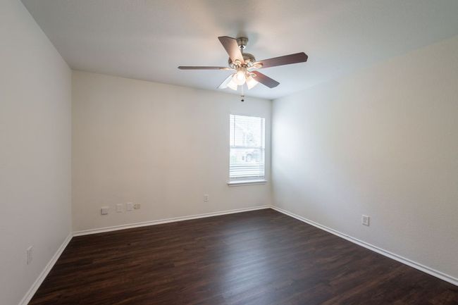 Spare room featuring dark wood-style floors, ceiling fan, and baseboards | Image 23