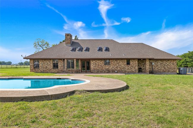 View of pool with french doors, central air condition unit, and a patio area | Image 19