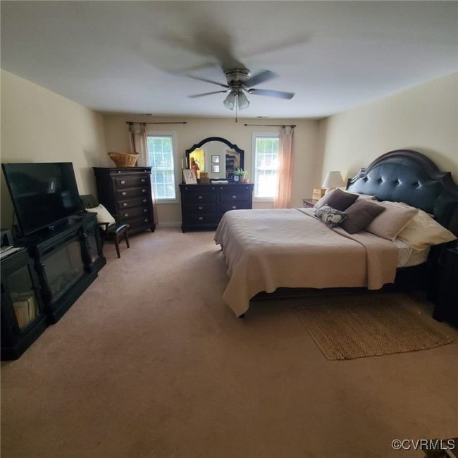 Bedroom featuring light colored carpet and a ceiling fan | Image 33