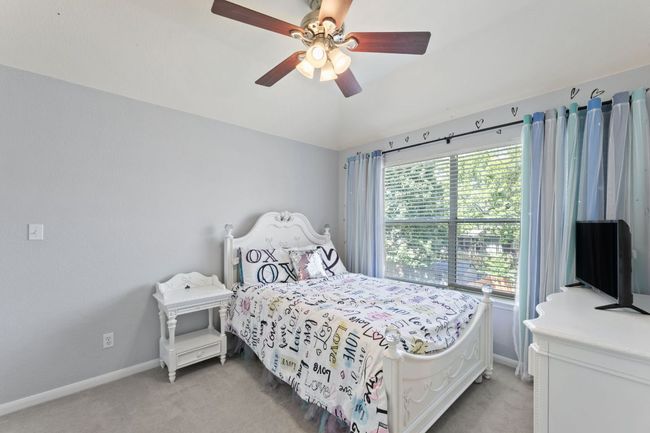 Bedroom with light carpet and a ceiling fan | Image 25
